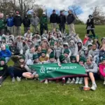 first-green-golf-image - Carroll News | Carroll Publications | Carroll County, MD Large group of students and instructors posing on a grassy hill, holding a green First Green banner.