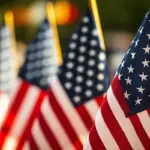july4th-image-carroll - Carroll News | Carroll Publications | Carroll County, MD Rows of American flags on flagpoles, close-up foreground flag with others blurred in the background at a patriotic display