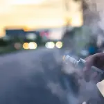 vape smoke_image - Carroll News | Carroll Publications | Carroll County, MD Person vaping from a car window at sunset, with vapor plume filling the air outside the vehicle.