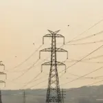 carroll-news-story-scaled - Carroll News | Carroll Publications | Carroll County, MD Series of tall metal transmission towers carrying high-voltage lines across a hazy sunset landscape.###